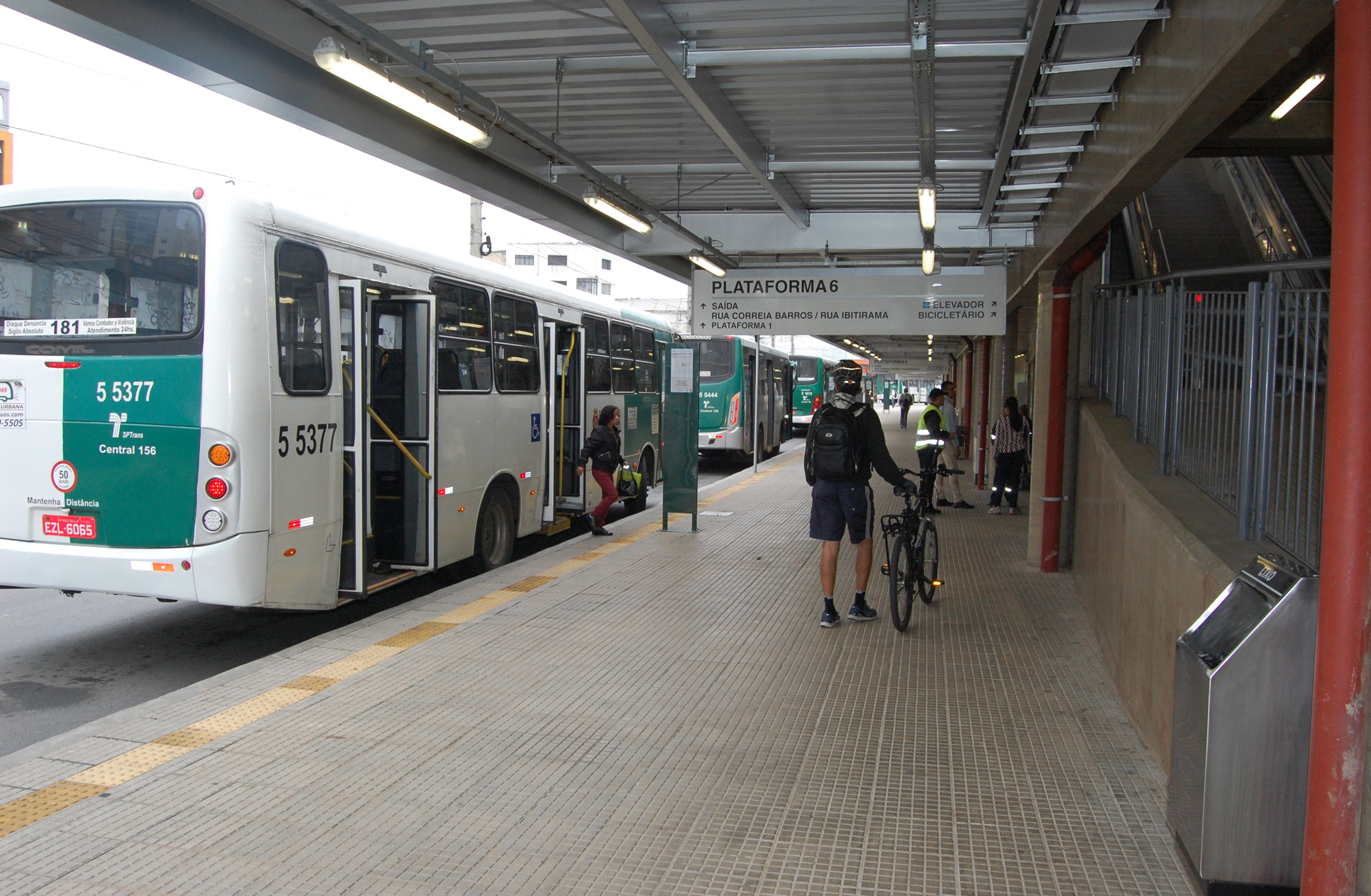 Imagem da plataforma 6 do terminal Vila Prudente, com um ônibus estacionado à esquerda da imagem, ao centro a plataforma com um ciclista e uma bicicleta.